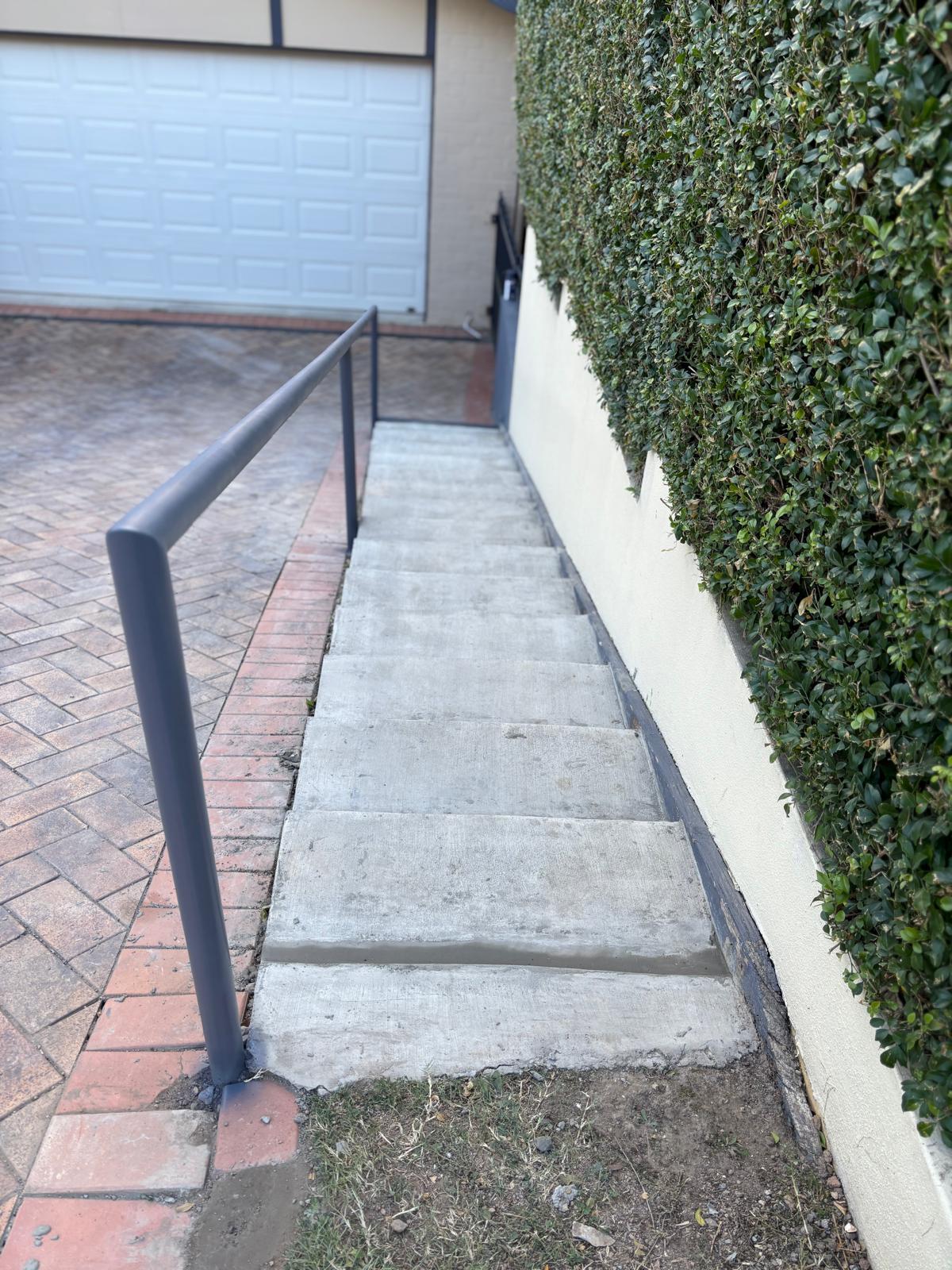 Concrete stairs with a metal handrail.