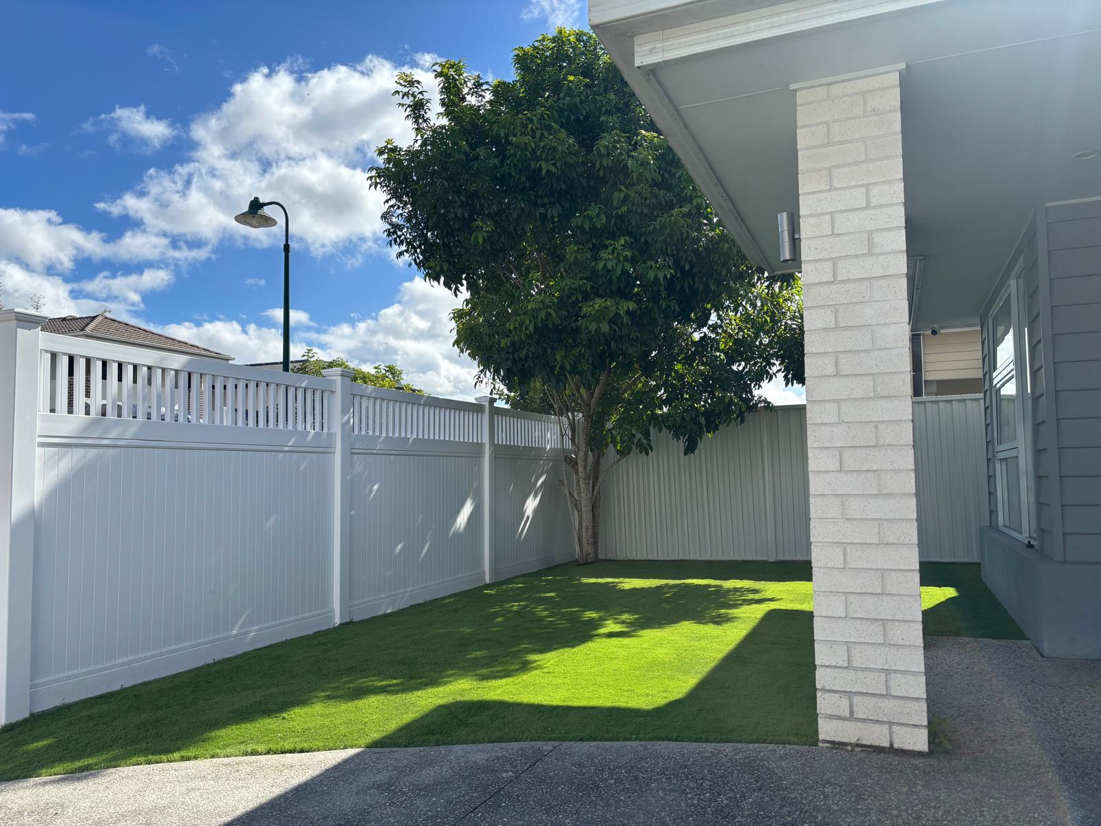 White PVC fence, synthetic grass, Colourbond fencing