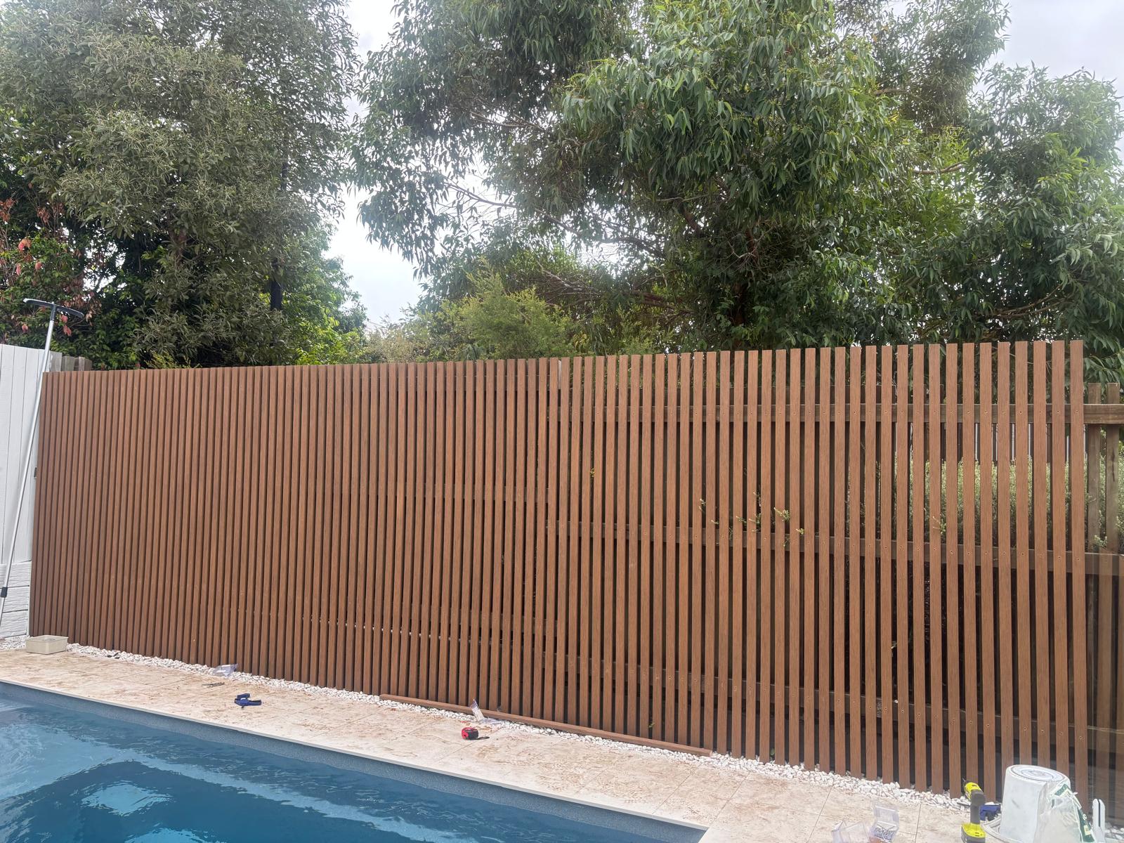 Brown timber paling fence beside a swimming pool